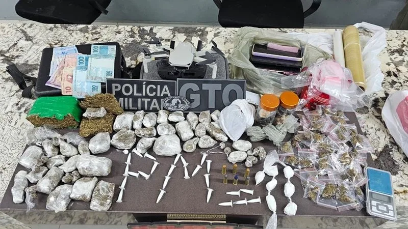 Itens apreendidos pela Polícia Militar incluindo drone, drogas e munições.