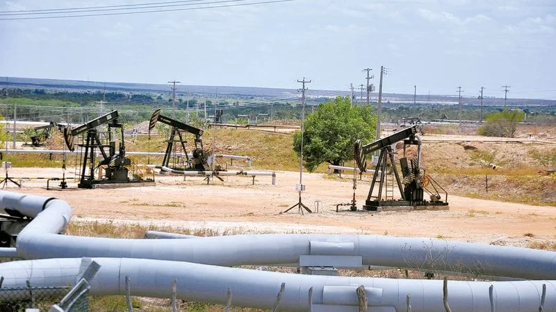 Torres de extração de petróleo em campo terrestre no RN.