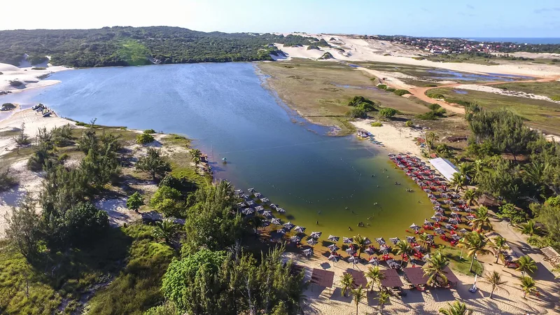 Vista panorâmica de lagoa no litoral do Rio Grande do Norte com turistas em destaque.