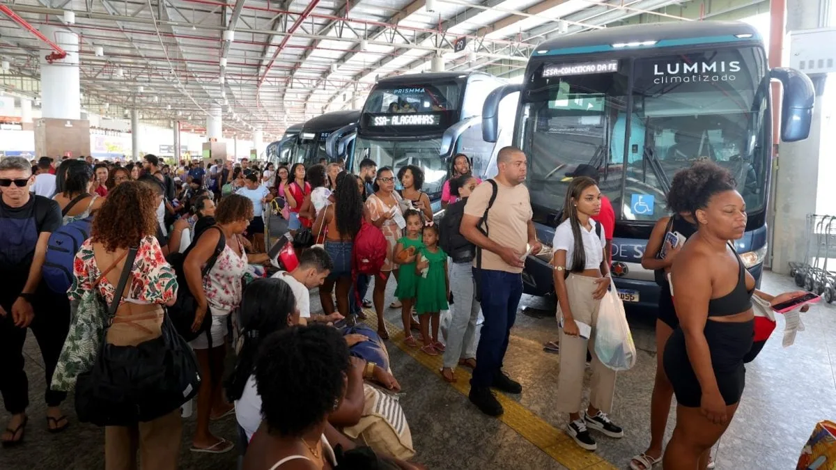 Terminal de ônibus urbano com movimento de passageiros.