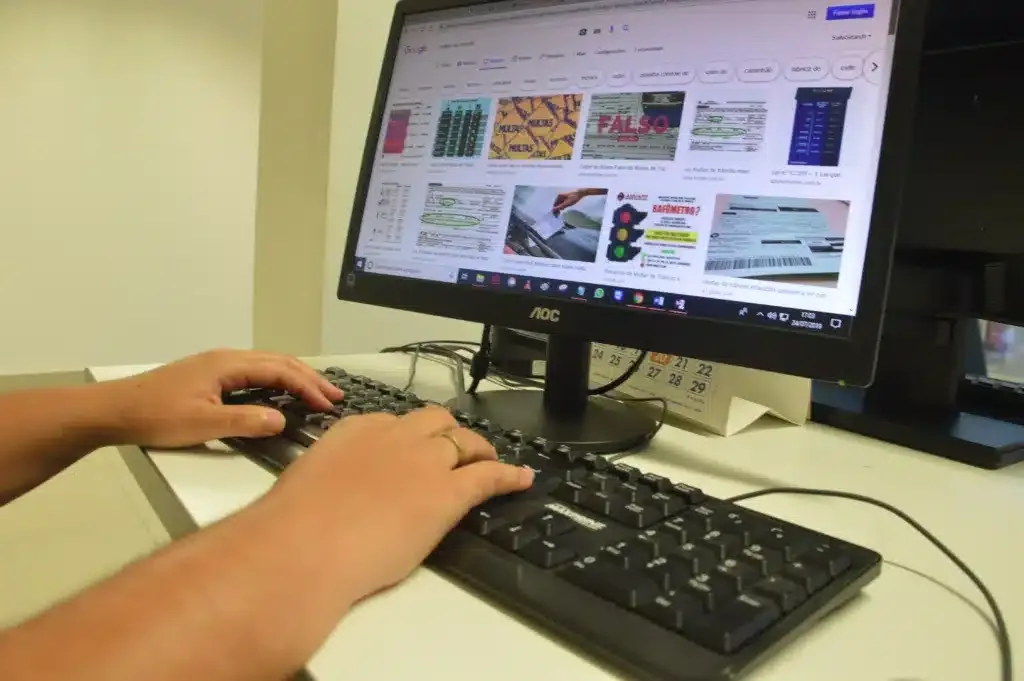 Pessoa utiliza teclado diante de um monitor de computador para realizar cursos técnicos.