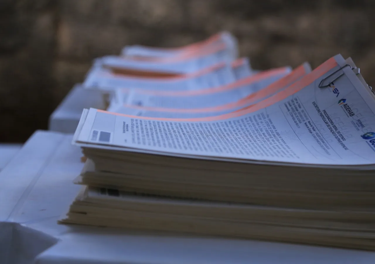Escrituras de imóveis empilhadas representando serviços cartoriais