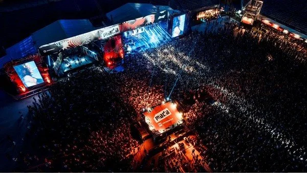 Palco do Festival MADA lotado durante apresentação musical.