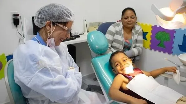 Crianças sendo atendidas em consultório odontológico com apoio do GACC-RN.