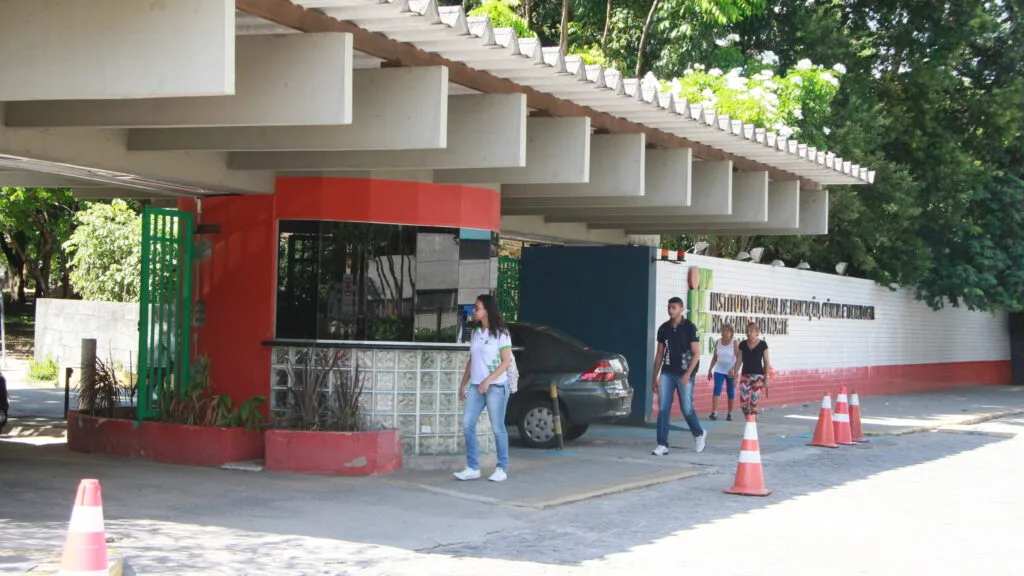 Fachada do campus Natal-Central do IFRN com movimentação de estudantes.