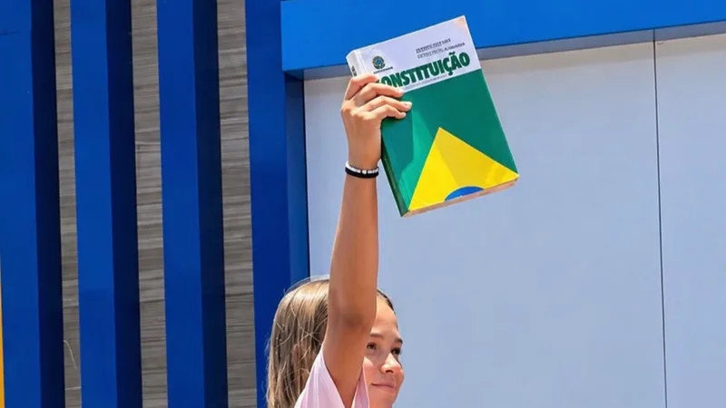 Uma menina ergue a Constituição Federal em meio a apoiadores no bairro do Alecrim.