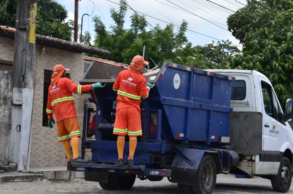 Caminhão de coleta de lixo da Urbana realizando serviço em rua de Natal.