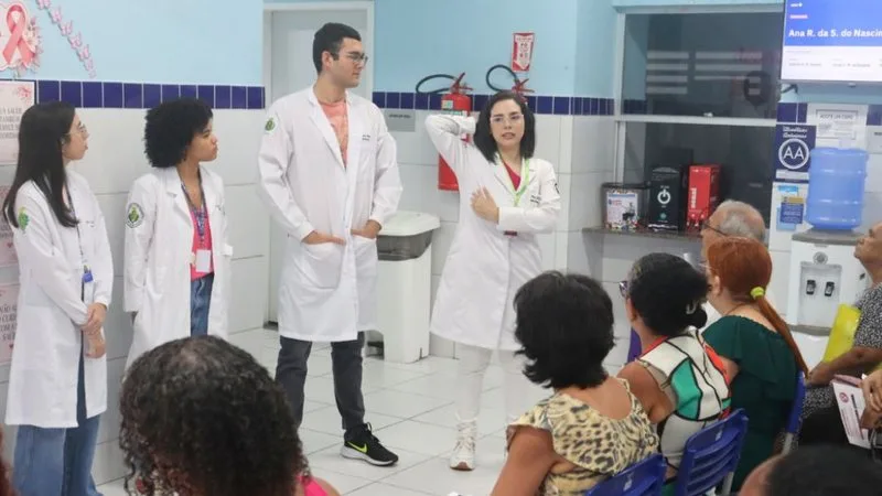 Equipe de saúde realizando atendimento durante o Outubro Rosa.