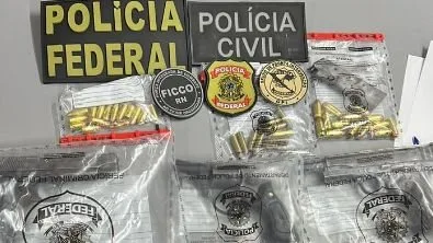 Armas de fogo apreendidas sobre uma mesa durante operação policial.