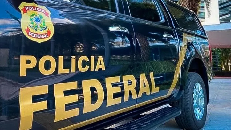 Viaturas da Polícia Federal em frente a uma delegacia.