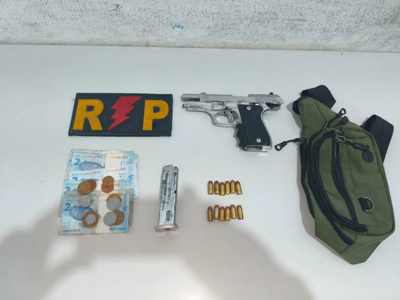 Pistola calibre .380 e munições apreendidas pela Polícia Militar.