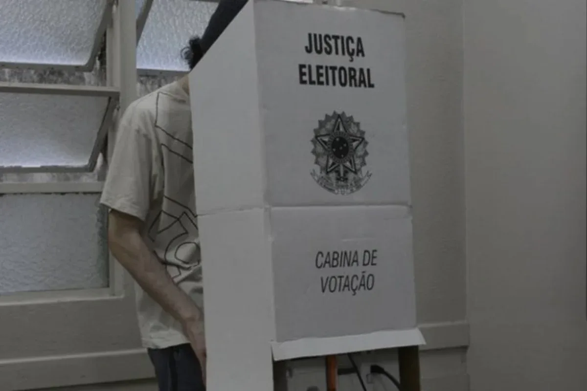 Eleitores comparecendo às urnas usando camisas com símbolos de partidos e candidatos.
