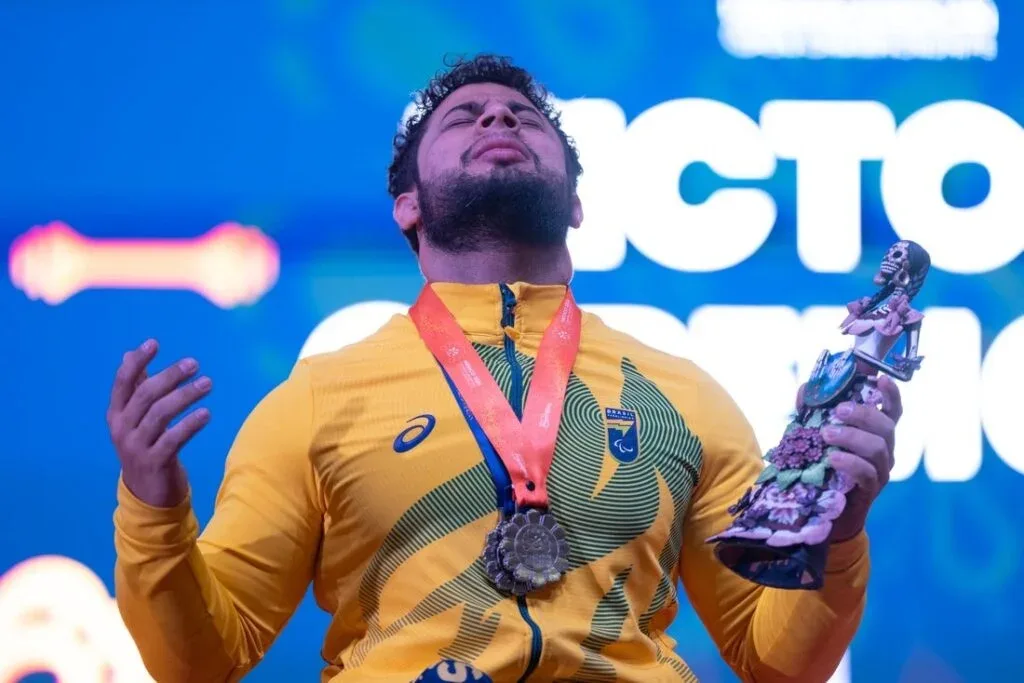 Atleta de halterofilismo celebrando medalha em competição internacional