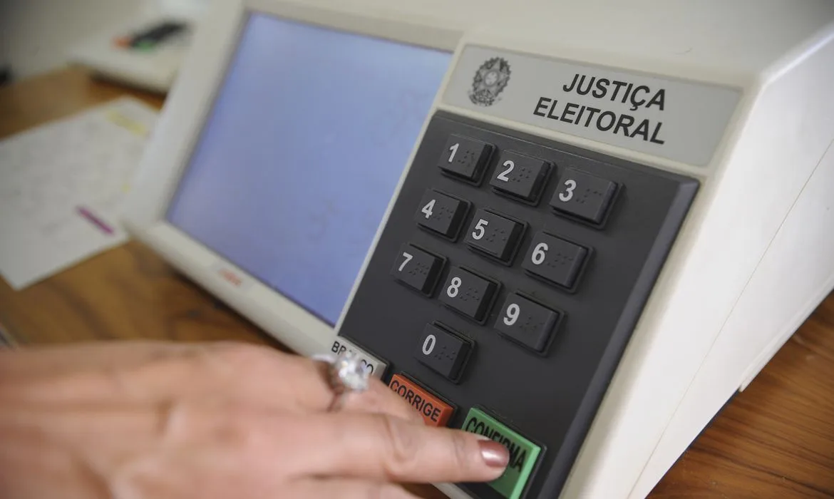 Urnas eletrônicas dispostas em seção eleitoral.