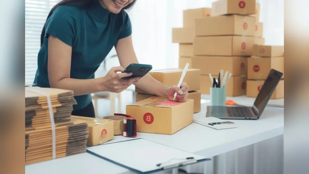 Mulher trabalha em ambiente de home office com dispositivos móveis e embalagens.