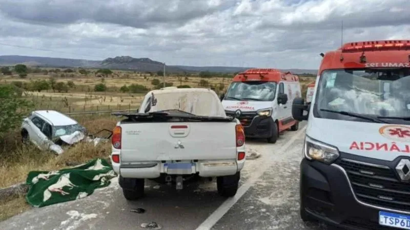 Equipes de resgate e viaturas na rodovia após colisão frontal entre dois carros.