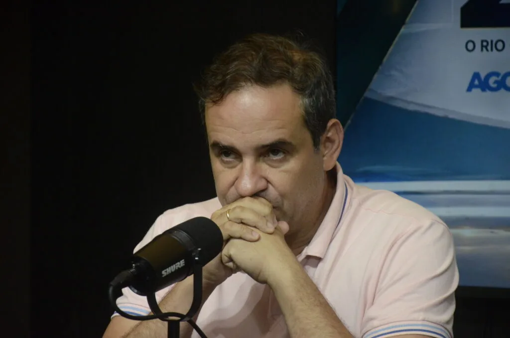 Cadu de Lula em entrevista, com microfone posicionado.