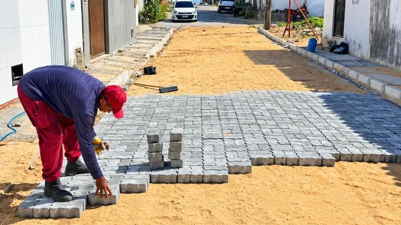Trabalhadores instalando pavimentação em rua da Zona Norte de Natal.